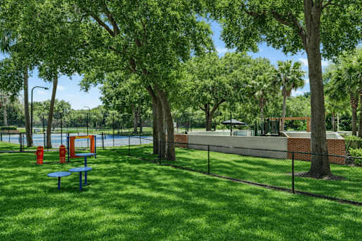A park with a blue bench and a red object. at Epic Apartments , Daytona Beach