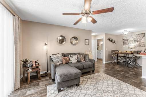A living room with a grey couch and a wooden coffee table. at Epic Apartments , Florida