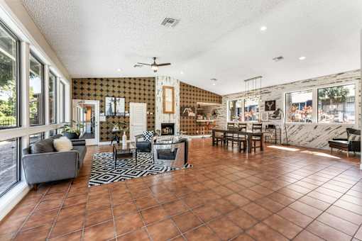 A living room with a grey couch and a black and white rug. at Epic Apartments , Daytona Beach, Florida