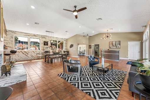 A living room with a black and white rug and brown tiled flooring. at Epic Apartments , Daytona Beach, 32114