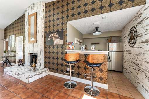 A kitchen with a bar stool and a fridge. at Epic Apartments , Daytona Beach
