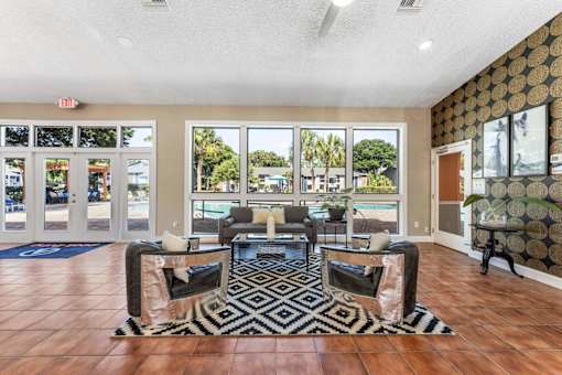 A living room with a black and white patterned rug in front of a glass door. at Epic Apartments , Daytona Beach