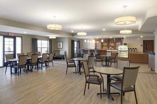 Community dining room with bistro seating at The Estates at Arbor Oaks Apartments, Andover, 55304