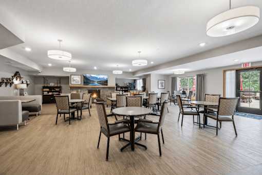Community dining area with round tables and modern lighting at The Estates at Arbor Oaks Apartments, Andover, Minnesota