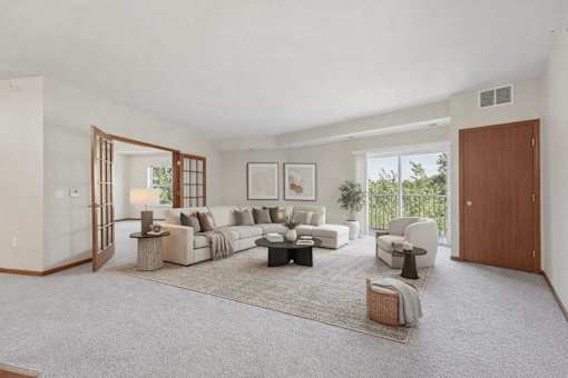 Living room with sectional sofa and balcony access at The Estates at Arbor Oaks Apartments, Minnesota