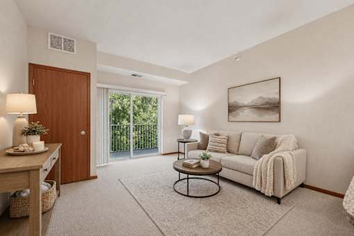 Cozy living room with vaulted ceiling and patio door at The Estates at Arbor Oaks Apartments, Minnesota