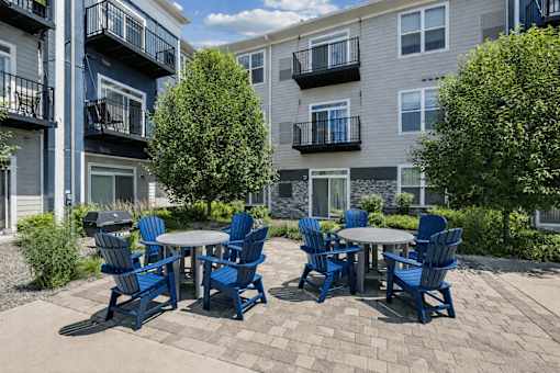 A patio with a table and chairs in front of apartment buildings.