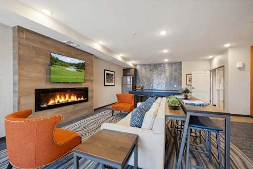 A modern living room with a fireplace and a television displaying a golf course.