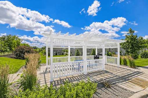 A white wooden structure with a porch and a white picket fence.