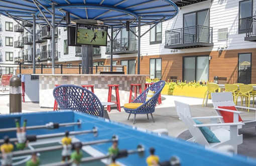 Outdoor courtyard with colorful seating and games at Hello Apartments, Minneapolis, MN 55427