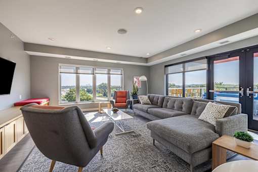 Modern living room with sectional sofa and pool access at Hello Apartments, Minneapolis, MN