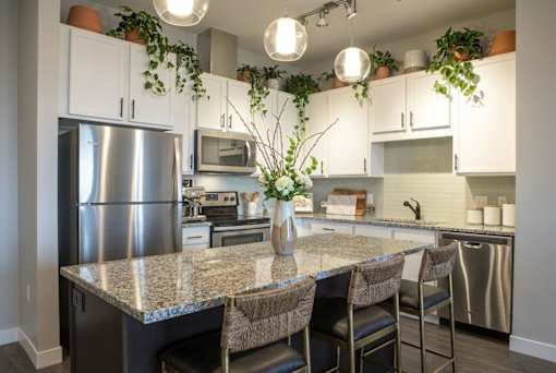 Kitchen with island seating and stainless appliances at Hello Apartments, Minneapolis, Minnesota