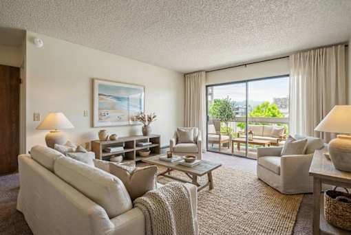 A well-lit living room with a large window and a view of the city.