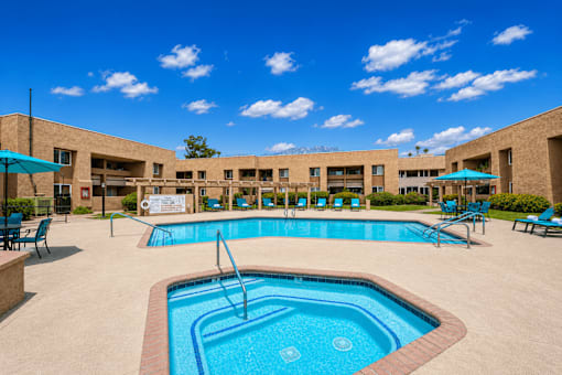 A large outdoor swimming pool with a fountain in the middle.
