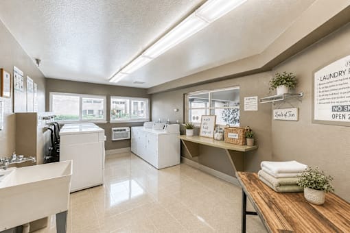 A laundry room with a washer and dryer, a table with towels, and a sign that says "NO SMOKING".