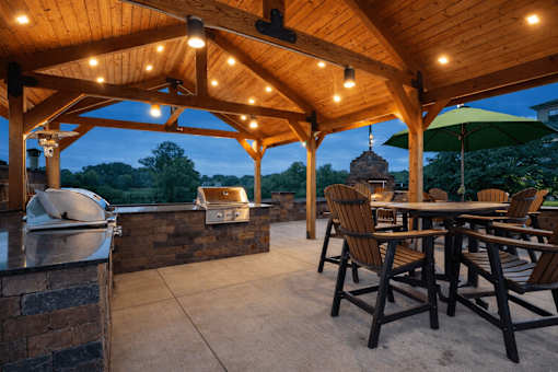 A wooden patio with a table and chairs under a roof at Aster Meadow, Vadnais Heights, MN, 55127