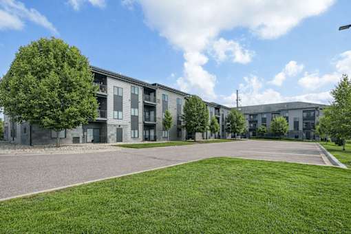 Apartment complex with a green lawn in front at Aster Meadow, Vadnais Heights, MN, 55127
