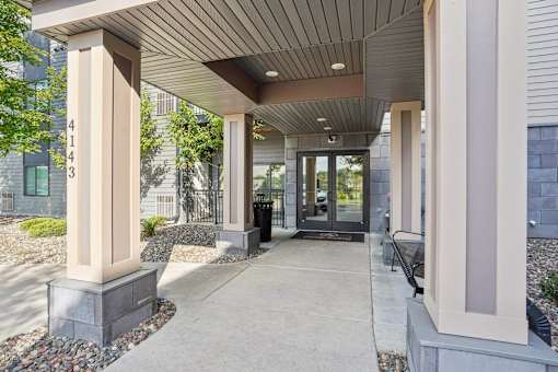 A building entrance with a concrete floor and a roof at Aster Meadow, Vadnais Heights, MN, 55127