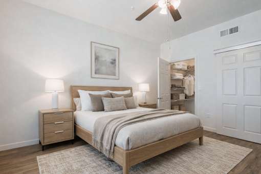 A bedroom with a bed, nightstand, and a ceiling fan.
