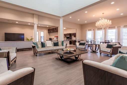 A spacious living room with a large sofa set and a chandelier.