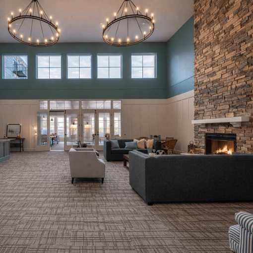 Spacious clubhouse lobby with stone fireplace at The Hendrickson Apartments, Falcon Heights, MN