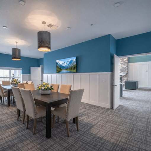 Community dining room with pendant lighting at The Hendrickson Apartments, Falcon Heights, Minnesota