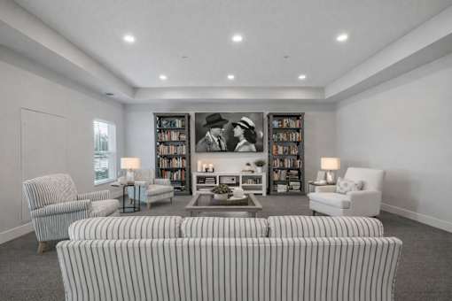 Theater room with striped seating and builtin shelving at The Hendrickson Apartments, Falcon Heights, Minnesota