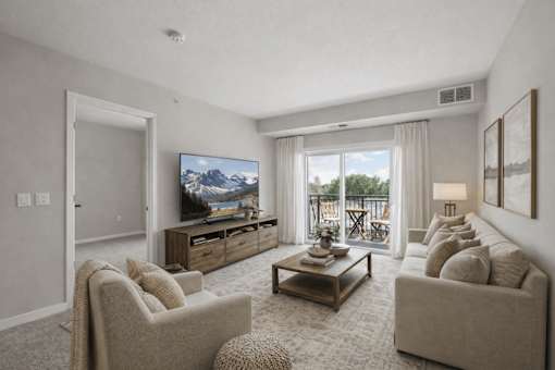 Living room with balcony and neutral furnishings at The Hendrickson Apartments, Falcon Heights