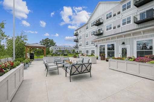 Outdoor terrace with lounge seating and planters at The Hendrickson Apartments, Minnesota