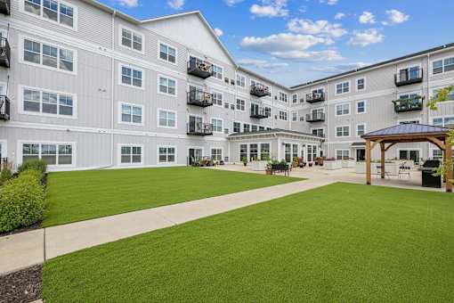 Courtyard with artificial turf and wooden pergola at The Hendrickson Apartments, Minnesota