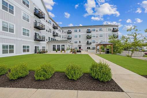 Courtyard with lawn and walkway to outdoor pavilion at The Hendrickson Apartments, Minnesota, 55113
