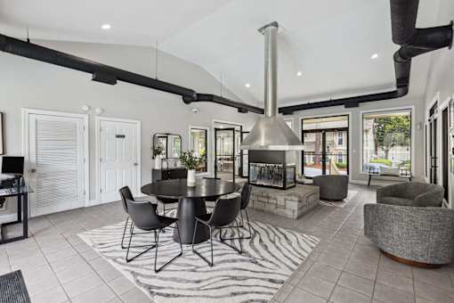 A modern kitchen with a black table and chairs.