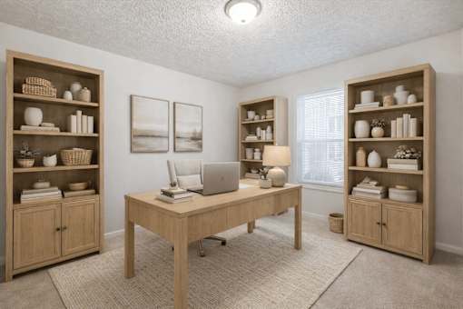 A room with a desk, chairs, and shelves filled with various items at Emerald Pointe, Riverdale, GA