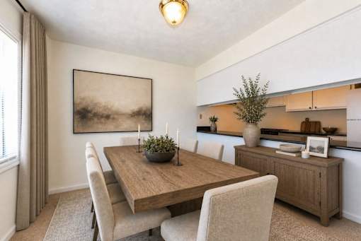 A dining room with a wooden table and chairs.