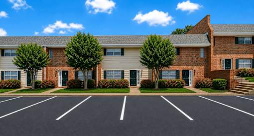 A parking lot in front of a brick building with trees.