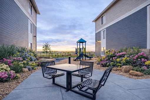 Outdoor picnic area with playground and gardens at Connect at First Creek Apartments, Colorado