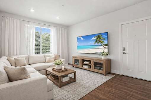 Living room with sectional sofa and entertainment center at Connect at First Creek Apartments, Denver, CO