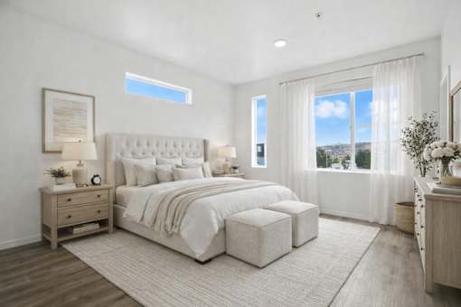 A bedroom with a large bed, nightstands, and a window overlooking the city.