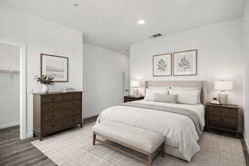 A bedroom with a large bed, a dresser, and a nightstand.