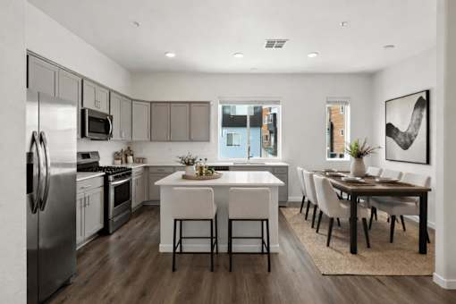 A modern kitchen with a dining table and chairs.