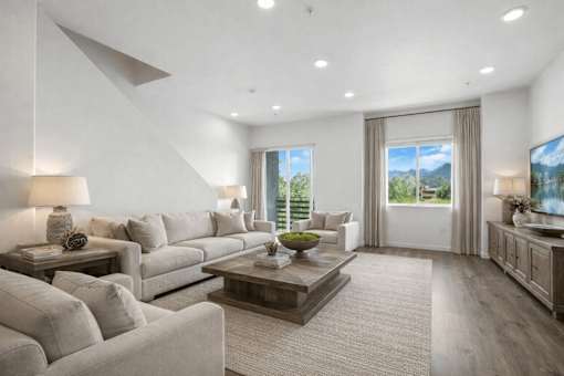 A modern living room with a large grey sofa and a wooden coffee table.