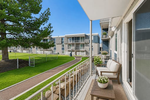 Private balcony with seating and courtyard views at Park Station Apartments, Midvale, Utah