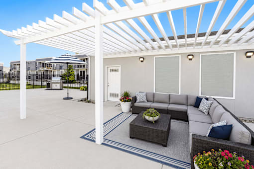 Outdoor lounge area with white pergola at Park Station Apartments, Midvale