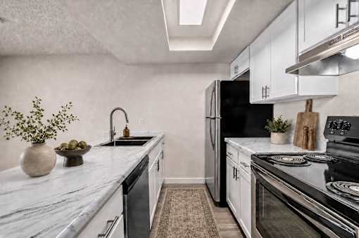Modern galley kitchen with marble countertops at Park Station Apartments, Midvale, UT