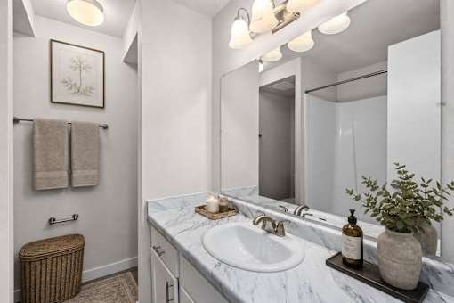 Bathroom vanity with marble countertop and mirror at Park Station Apartments, Midvale, Utah