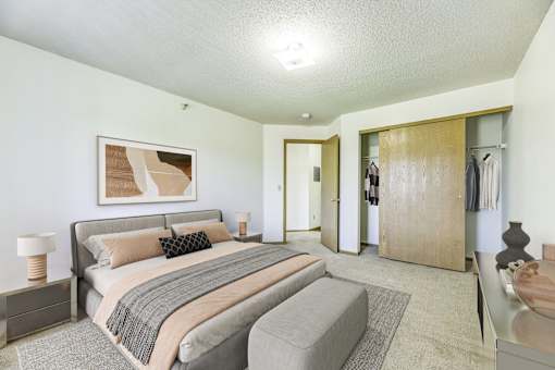 A bedroom with a large bed and a painting on the wall.