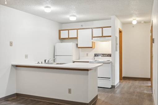 A kitchen with white appliances and a white counter.