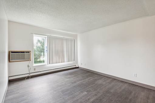 A room with a window and a wooden frame on the window.