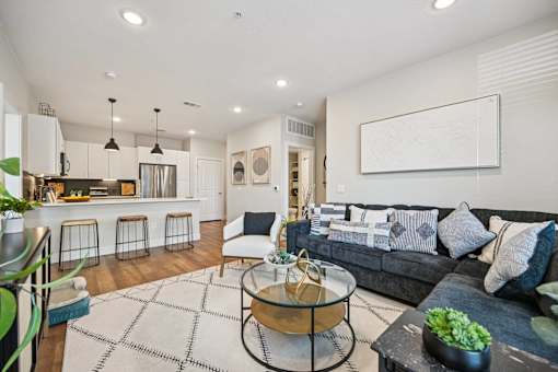 Open living space with kitchen and sectional sofa at Sequel Homes Apartments, Englewood, 80110
