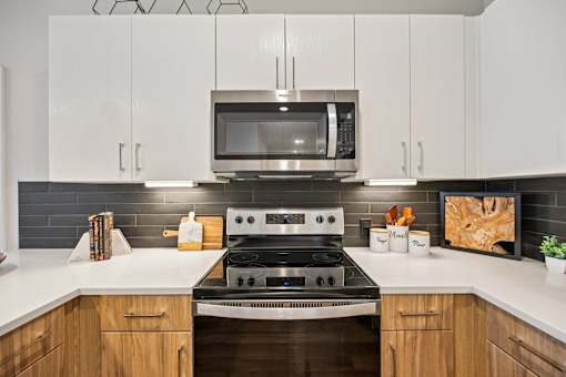 Kitchen with white cabinets and stainless steel range at Sequel Homes Apartments, Englewood, CO